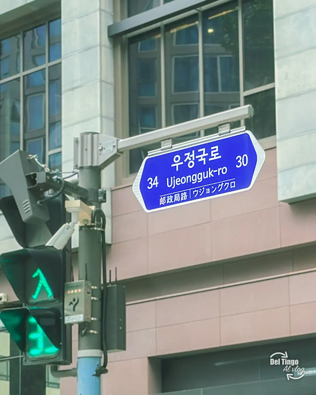 Señal bilingüe de Ujeongguk-ro junto a un semáforo peatonal en Seúl.