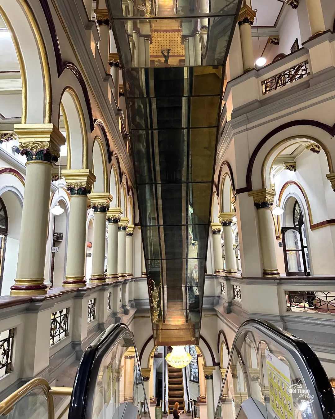 Las escaleras mecánicas atraviesan el interior histórico y muestran el contraste entre palacio y centro comercial.
