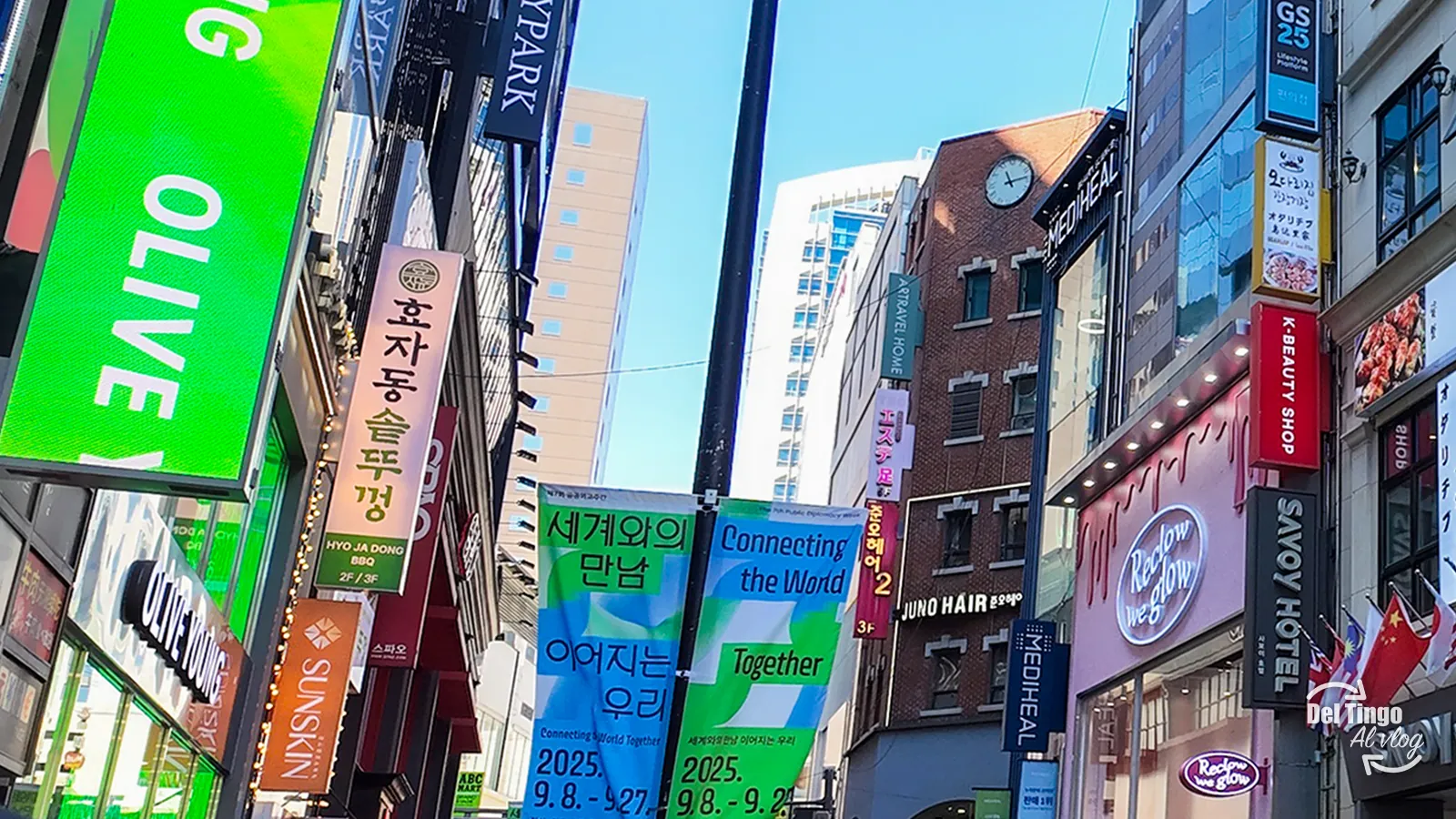 Calle de Myeongdong en Seúl llena de letreros comerciales y pancartas Connecting the World, con tiendas como Olive Young, Sunskin, Mediheal y K-Beauty Shop