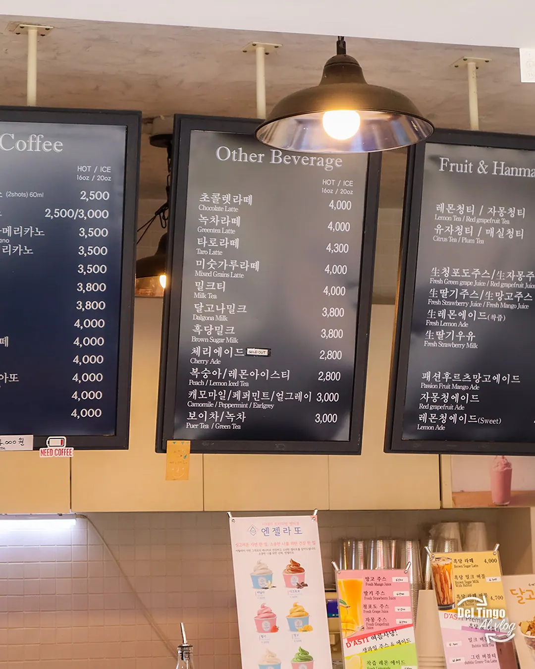 Tablero de menú de una cafetería coreana con secciones Coffee, Other Beverage y Fruit, mostrando precios en wones de bebidas como taro latte, milk tea y dalgona milk