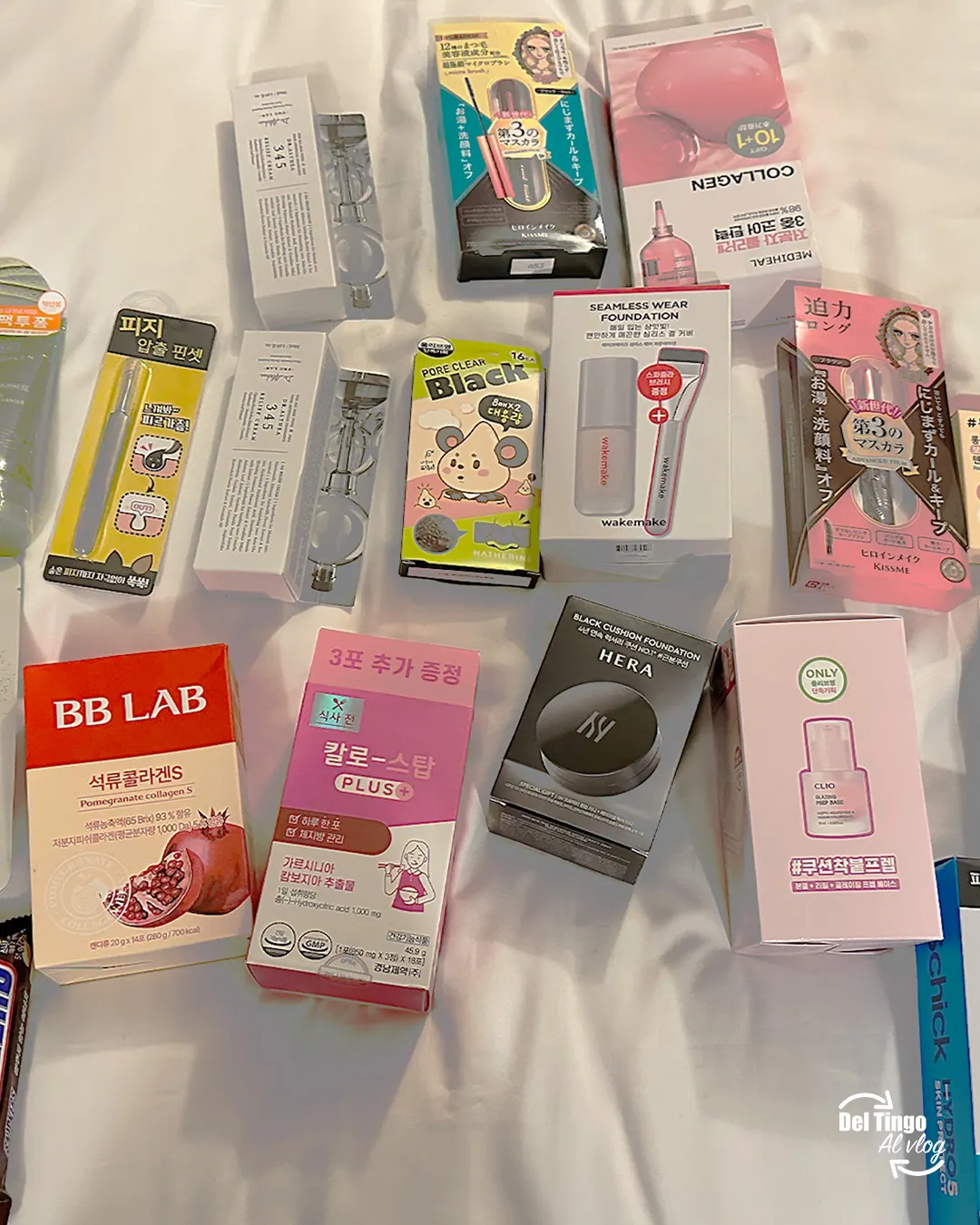 Productos coreanos comprados en Olive Young extendidos sobre una cama: cajas de colágeno, parches para acné, base, máscara y otros artículos de K-beauty