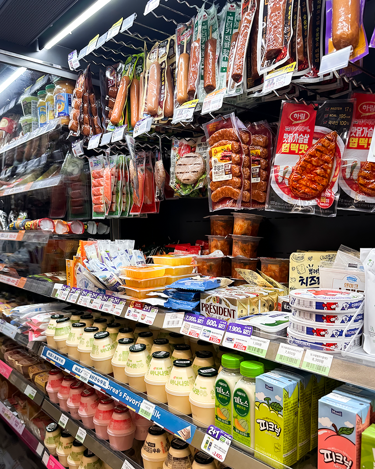 Sección de productos frescos en un 7-Eleven de Corea del Sur con embutidos, quesos y bebidas